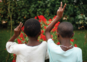Photographie de 2 enfants montrant le signe paix avec leurs doights