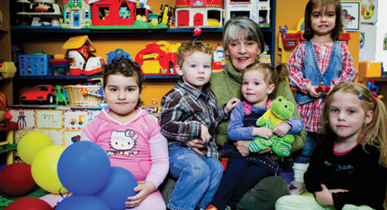 Photographie d'Odette Chartrand avec des enfants de sa garderie.