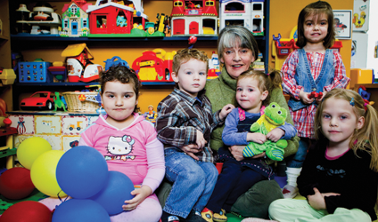Photographie d'Odette Chartrand avec des enfants de sa garderie.