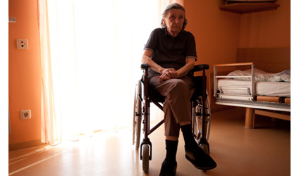 Photographie d'une dame âgée dans un fauteuil roulant.