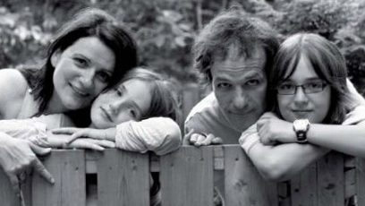 Photographie d’une famille accotée sur une clôture en bois