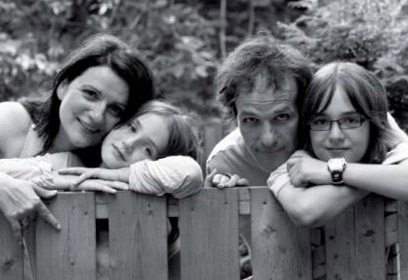 Photographie d’une famille accotée sur une clôture en bois