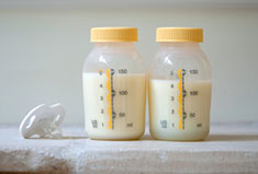 Photographie de 2 biberons remplis de lait.
