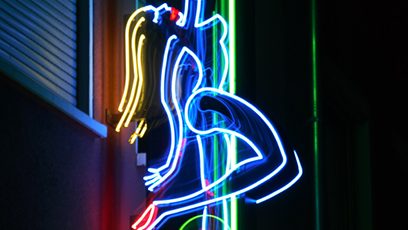 Photographie de l'insigne lumineuse d'un bar de danseuses nues