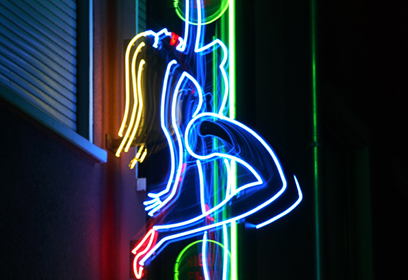 Photographie de l'insigne lumineuse d'un bar de danseuses nues