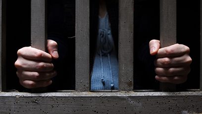 Photographie d’une personne dans une cellule de prison.