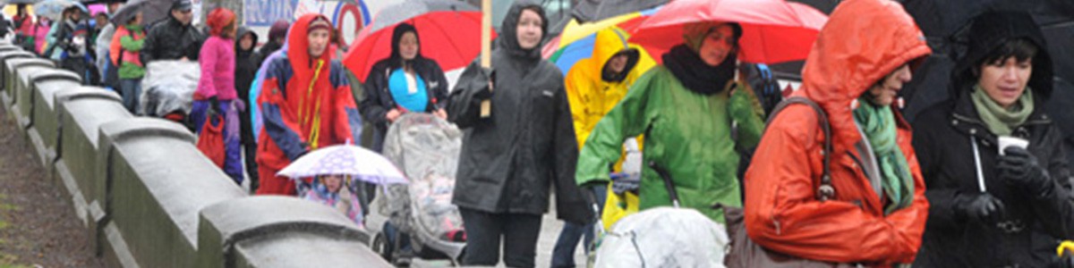 Photographie de marcheuses sous la pluie lors d'une manifestation.