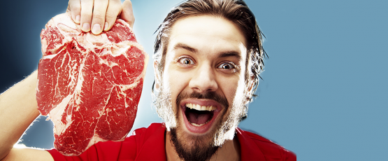 Photographie d'un homme tenant une tranche de steak dans la main.