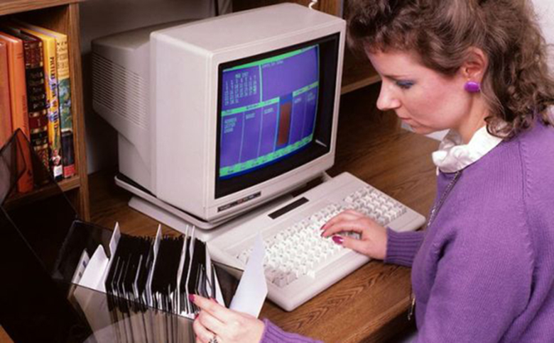 Jeune femme travaillant sur ordinateur des années 1970.